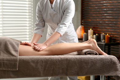Photo of Woman receiving leg massage in spa salon, closeup