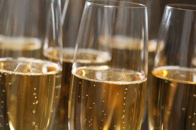 Many glasses of champagne as background, closeup view