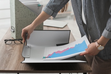 Businesswoman working with documents at office table, closeup