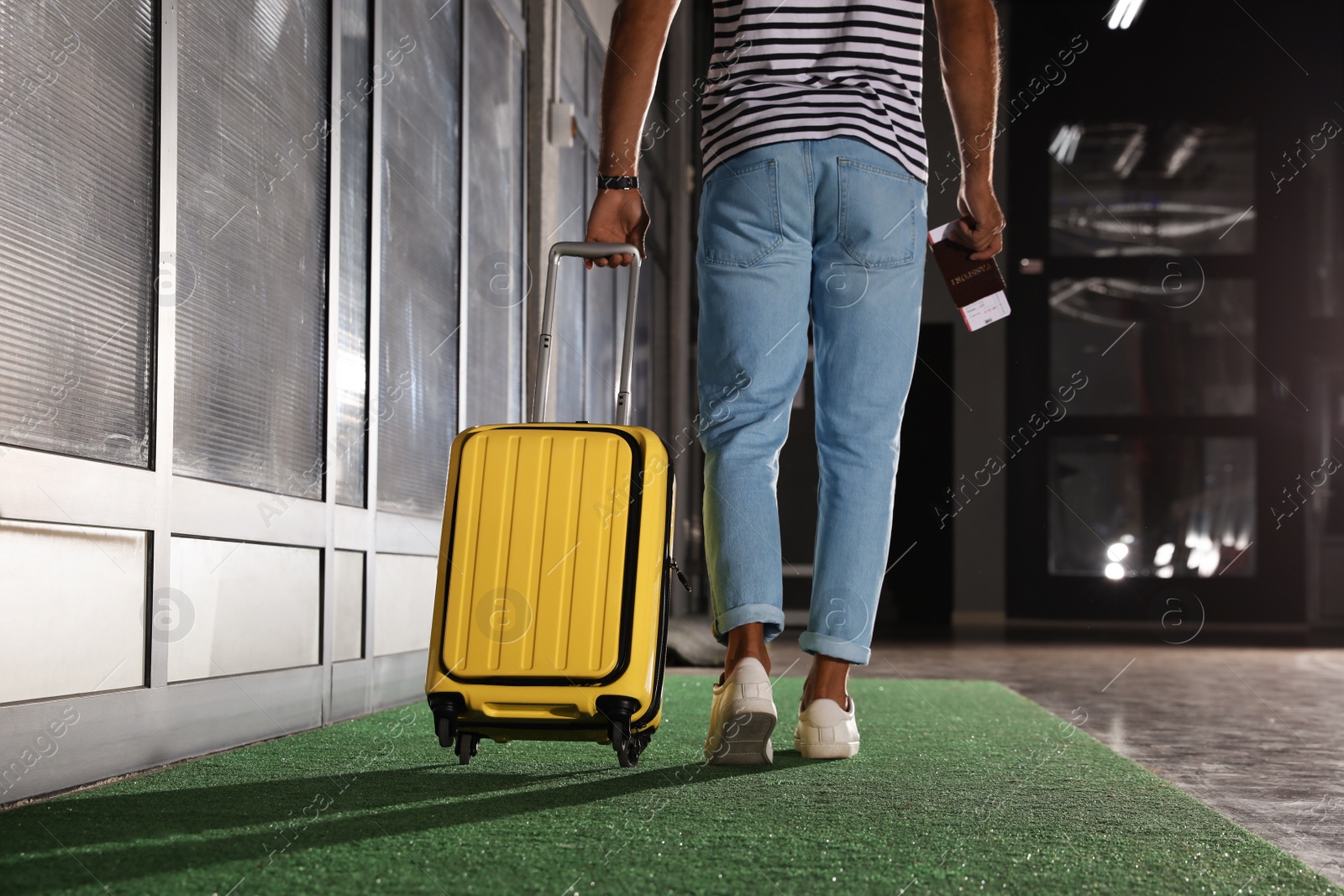 Photo of Man with yellow travel suitcase in airport