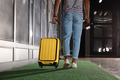 Man with yellow travel suitcase in airport