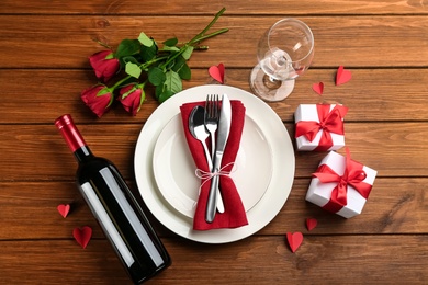 Beautiful table setting for Valentine's Day dinner on wooden background, flat lay