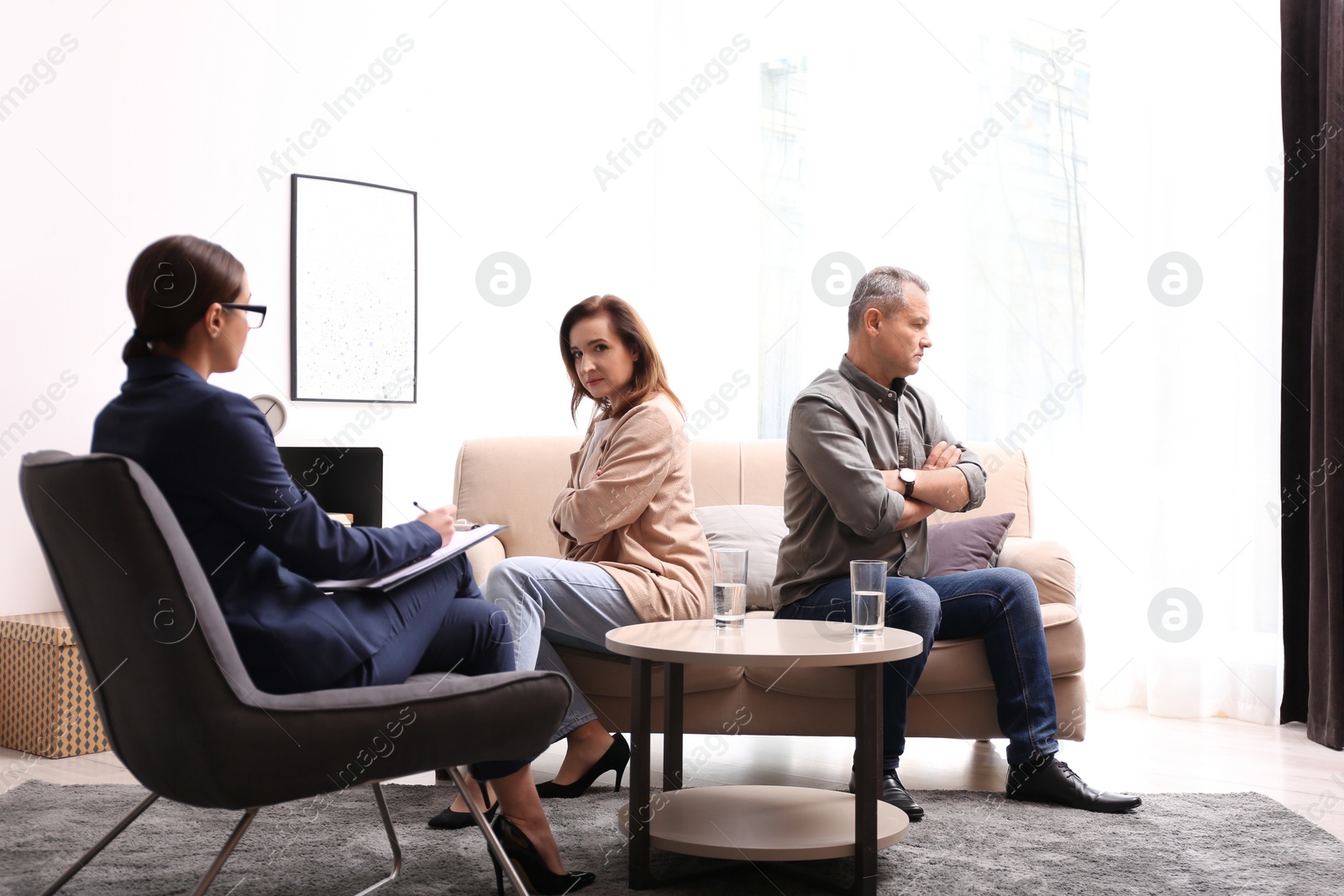 Photo of Psychotherapist working with couple in office. Family counselling