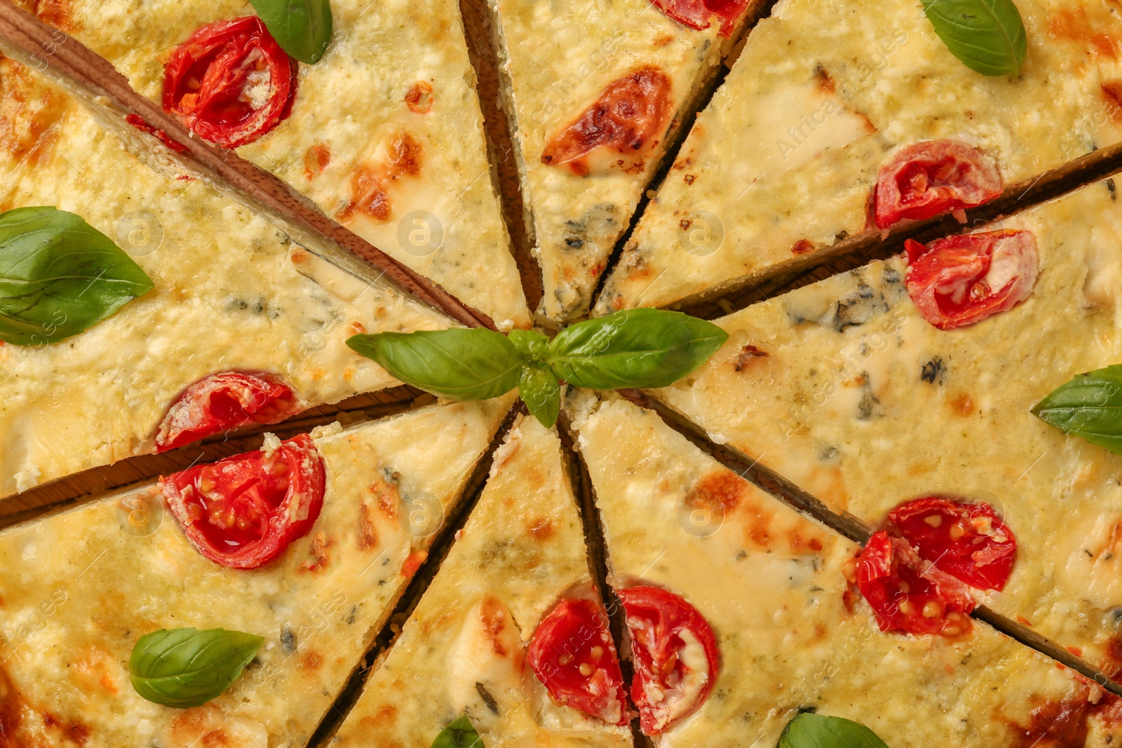 Photo of Delicious homemade cheese quiche on board, top view