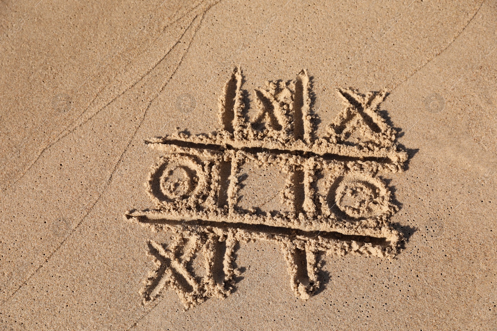 Photo of Tic tac toe game drawn on sandy beach