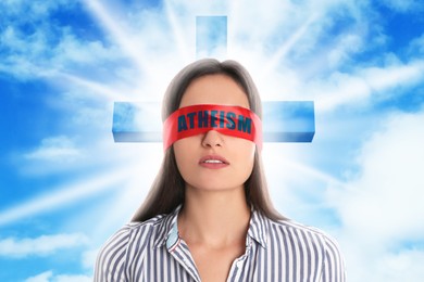 Image of Woman wearing red blindfold with word Atheism, sky with clouds and silhouette of cross on background
