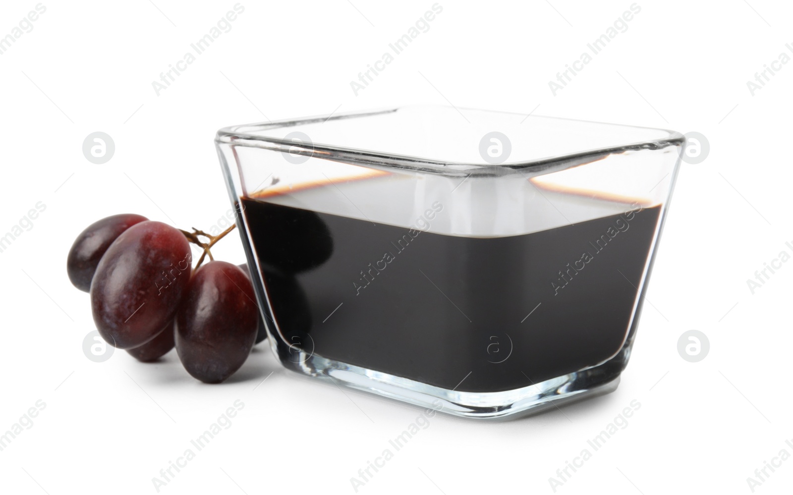 Photo of Balsamic vinegar in bowl and grapes isolated on white