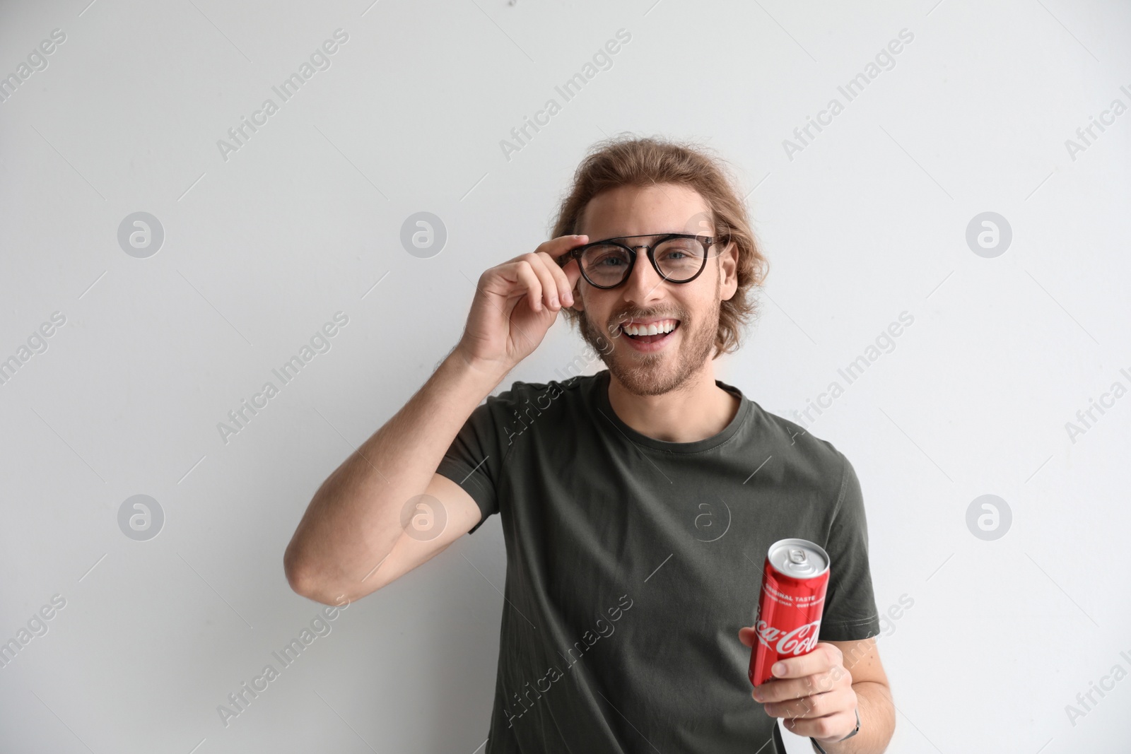 Photo of MYKOLAIV, UKRAINE - NOVEMBER 28, 2018: Young man with Coca-Cola can on white background