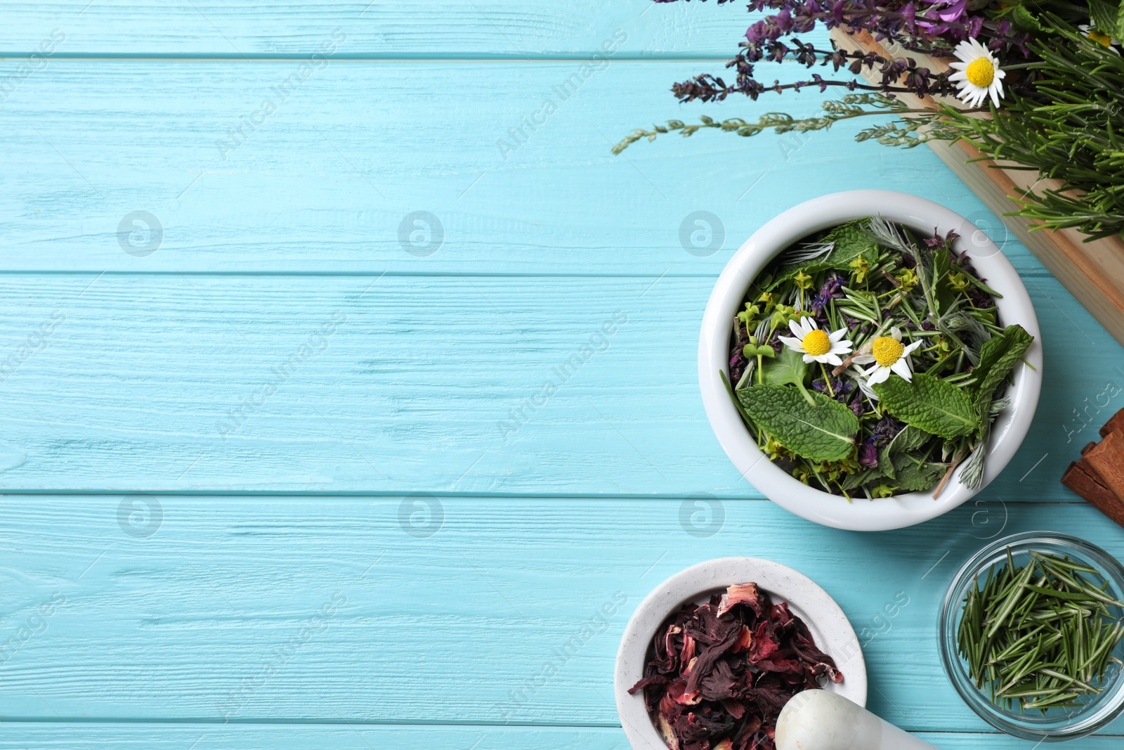 Photo of Flat lay composition with healing herbs on light blue wooden table. Space for text