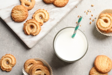 Photo of Flat lay composition with Danish butter cookies and glass of milk on grey background