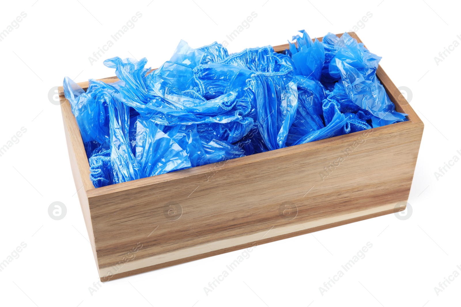 Photo of Blue medical shoe covers in wooden crate isolated on white