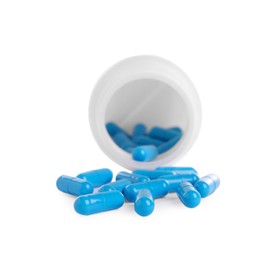 Photo of Medical bottle and blue pills on white background