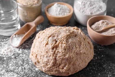 Fresh sourdough, flour and water on grey table