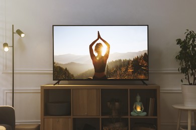 Image of Modern TV set on wooden stand in room