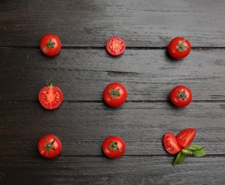 Photo of Flat lay composition with whole and cut cherry tomatoes on black wooden table