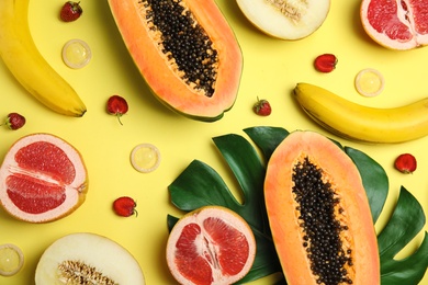 Photo of Flat lay composition with condoms and exotic fruits on yellow background. Erotic concept