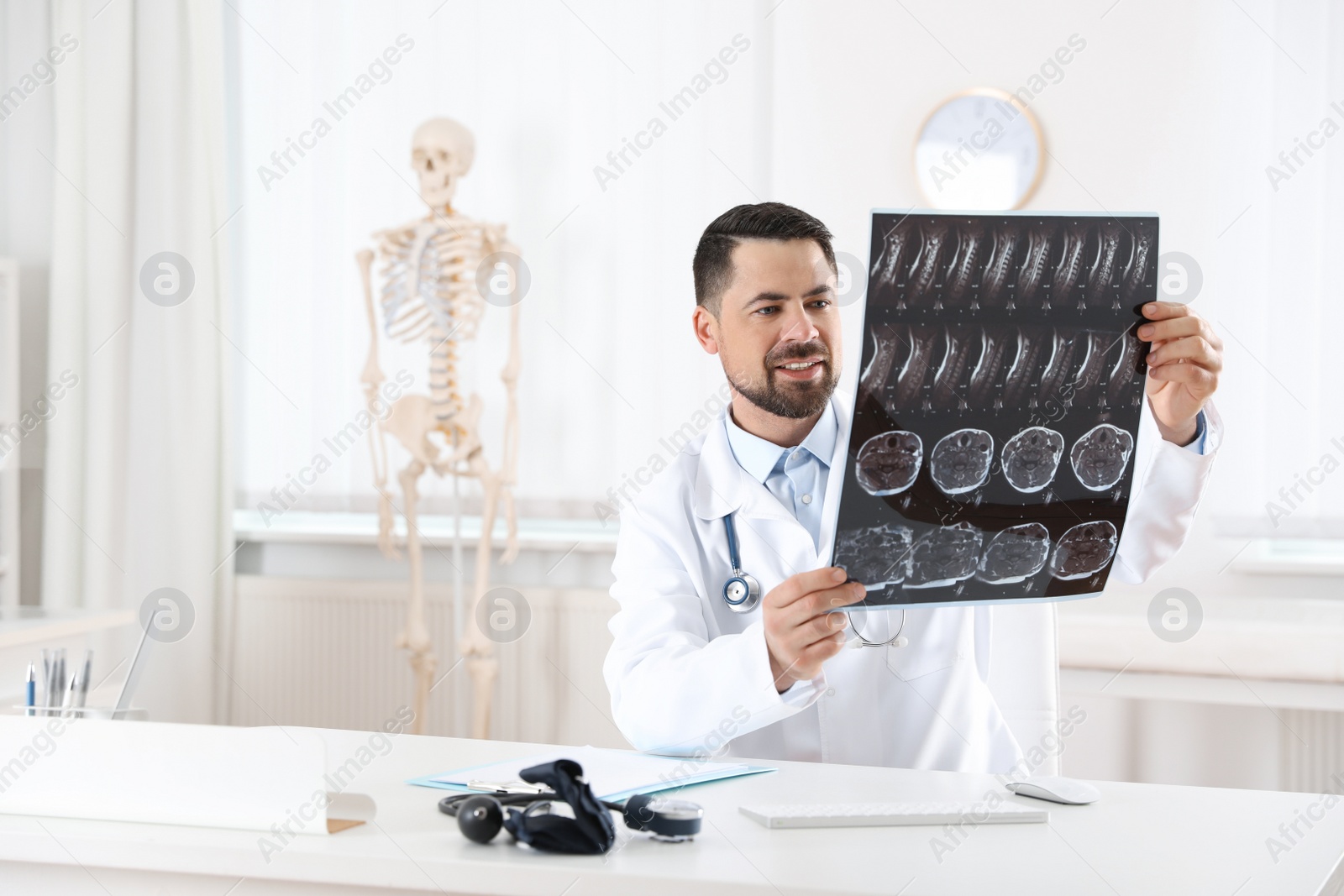 Photo of Orthopedist examining X-ray picture at desk in clinic