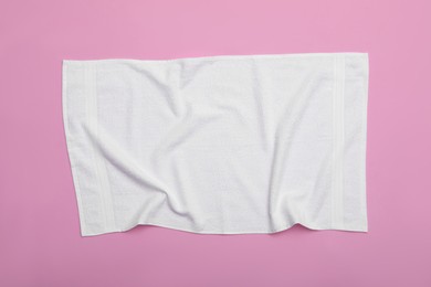 Crumpled white beach towel on pink background, top view