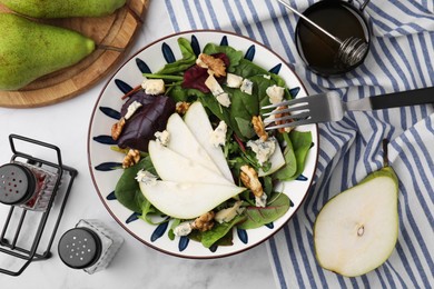 Photo of Delicious pear salad in bowl served on white table, flat lay