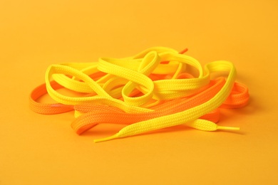 Photo of Different colorful shoe laces on yellow background