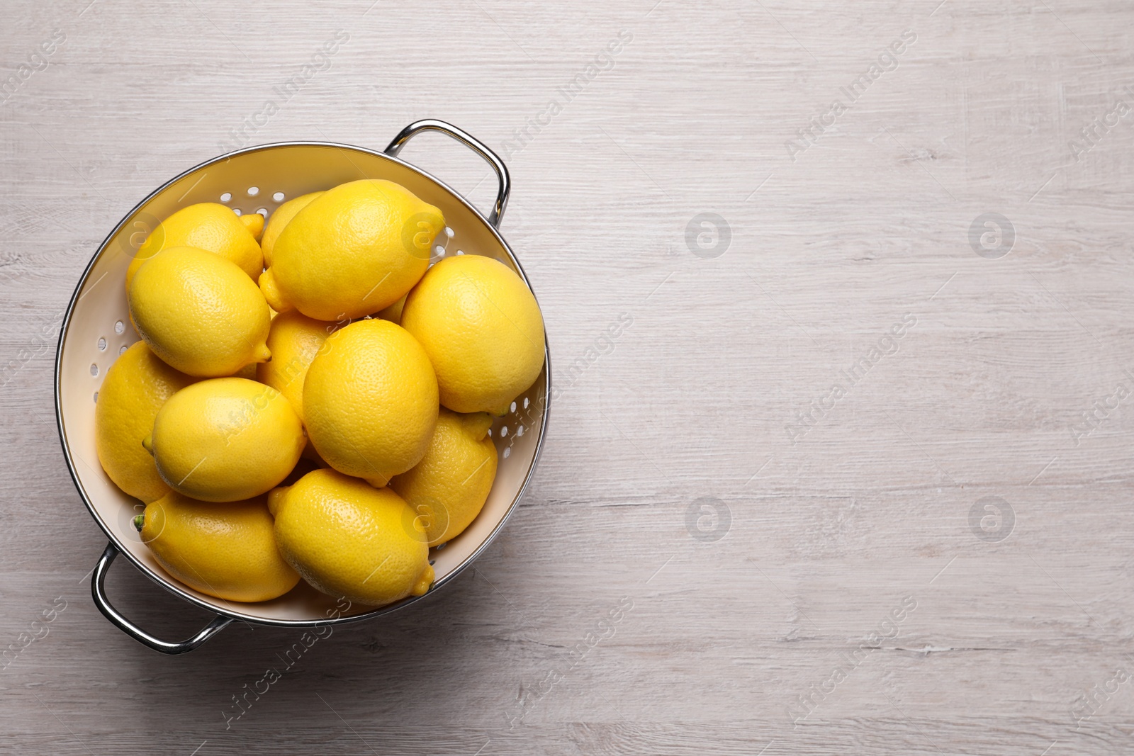 Photo of Many fresh ripe lemons on wooden table, top view. Space for text