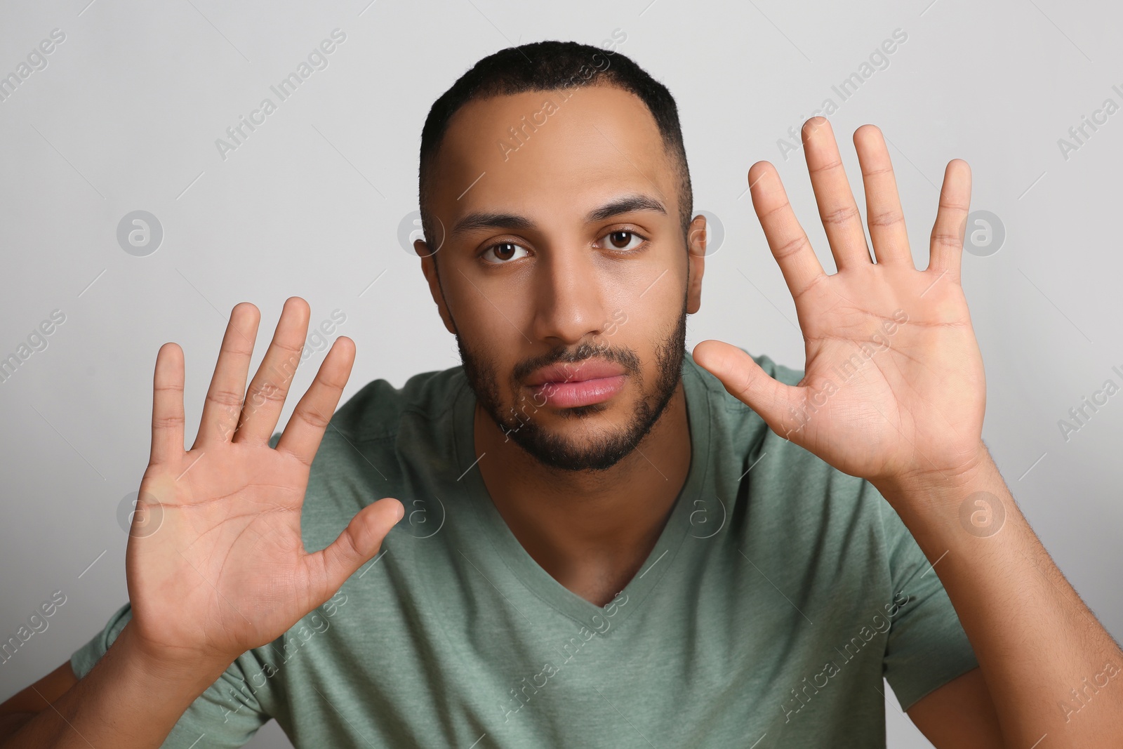 Photo of Young man stuck to transparent screen. Internet addiction concept