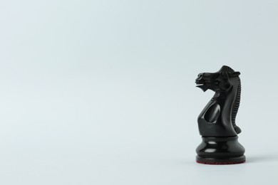 Photo of Black knight on light background, space for text. Chess piece