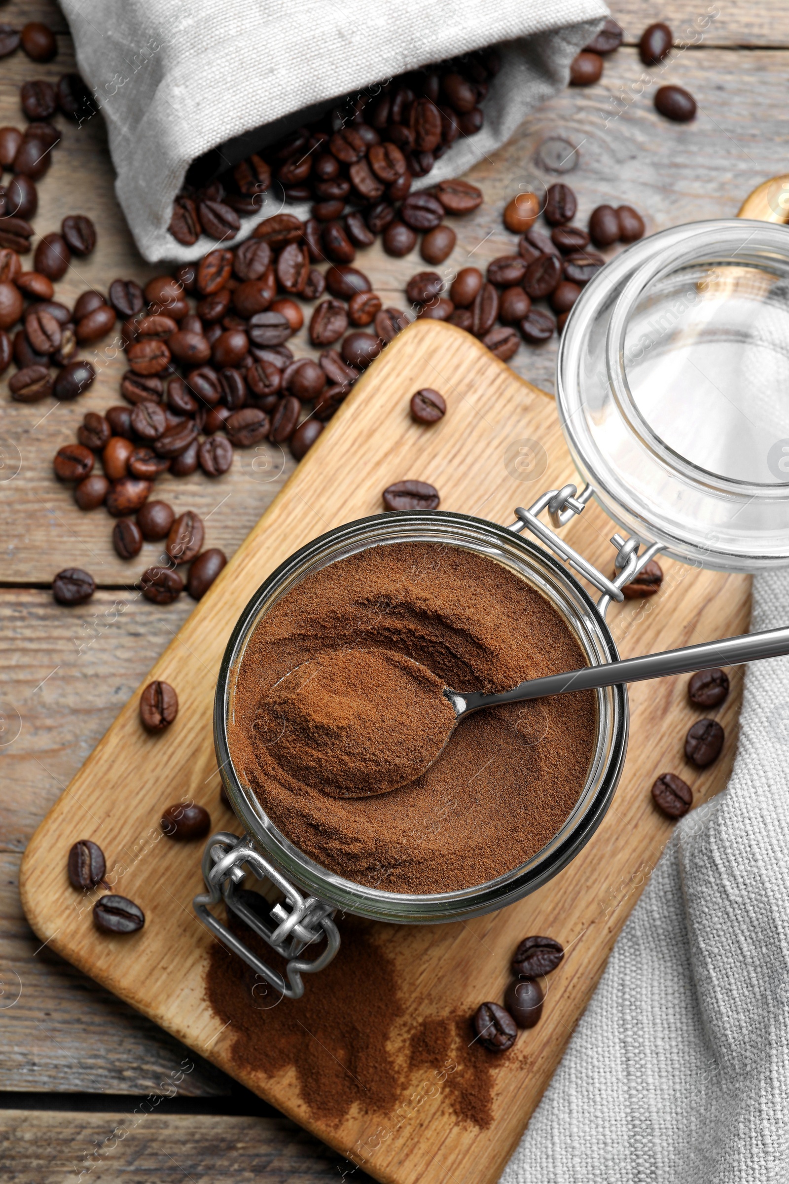 Photo of Glass jar of instant coffee and spoon on wooden table, flat lay