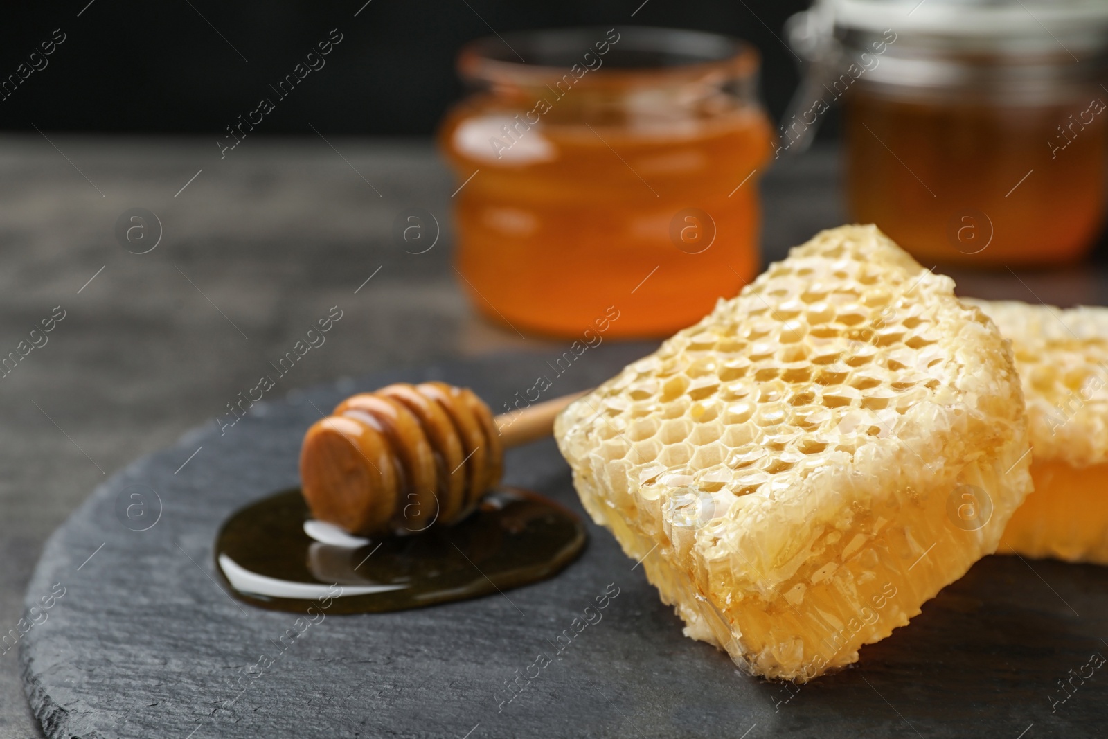 Photo of Slate plate with fresh honeycombs on table, closeup