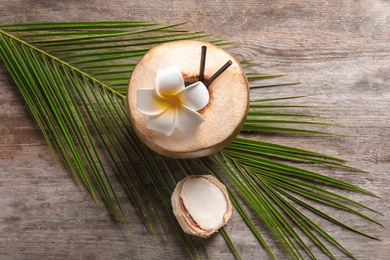 Photo of Beautiful composition with fresh green coconut and palm leaf on wooden background