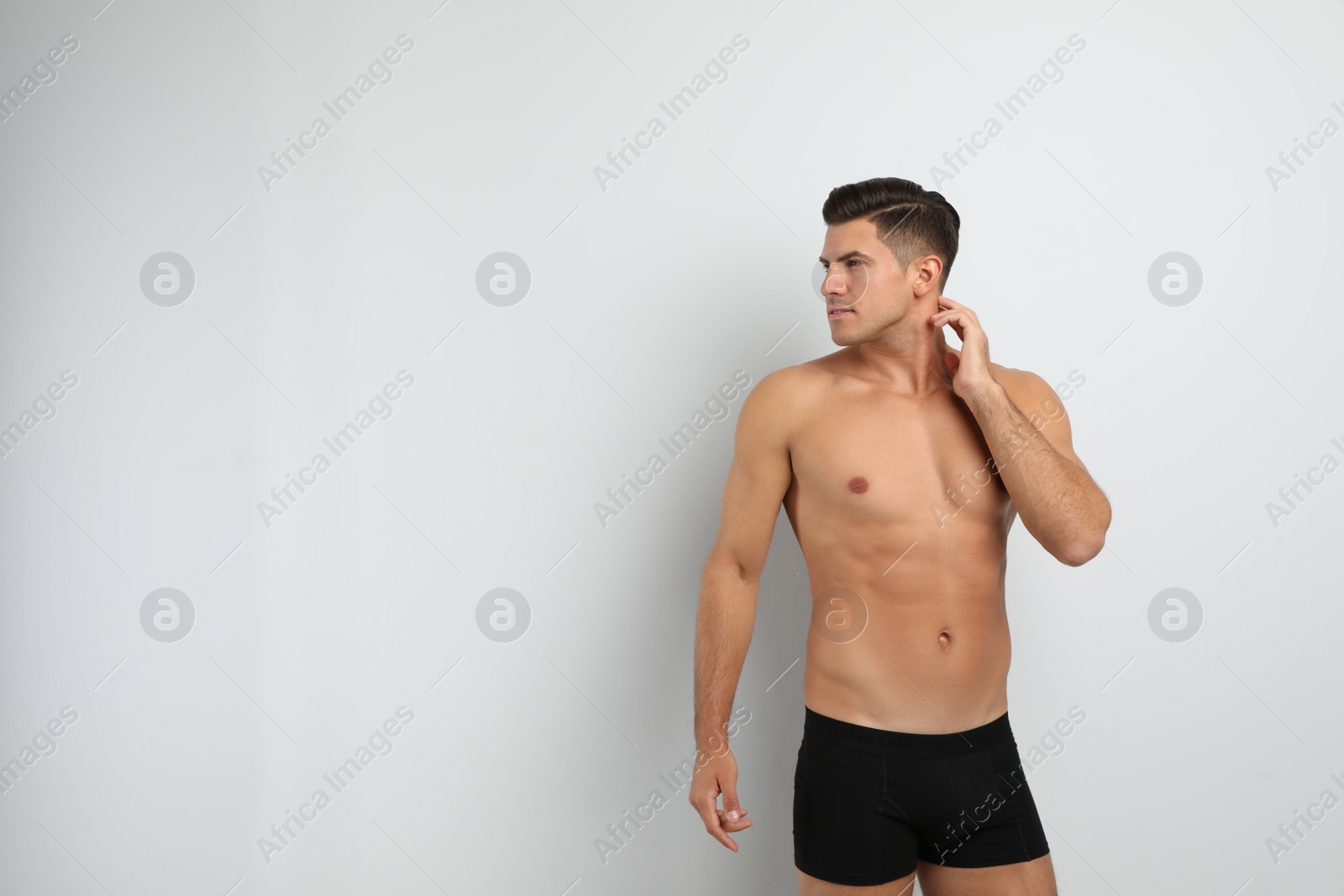 Photo of Handsome man in black underwear on white background. Space for text
