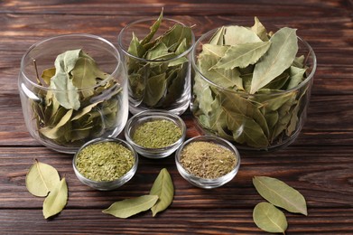 Photo of Whole and ground bay leaves on wooden table