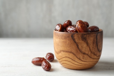 Bowl with sweet dates on table, space for text. Dried fruit as healthy snack