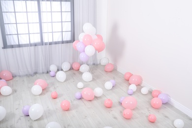 Room decorated with colorful balloons near wall