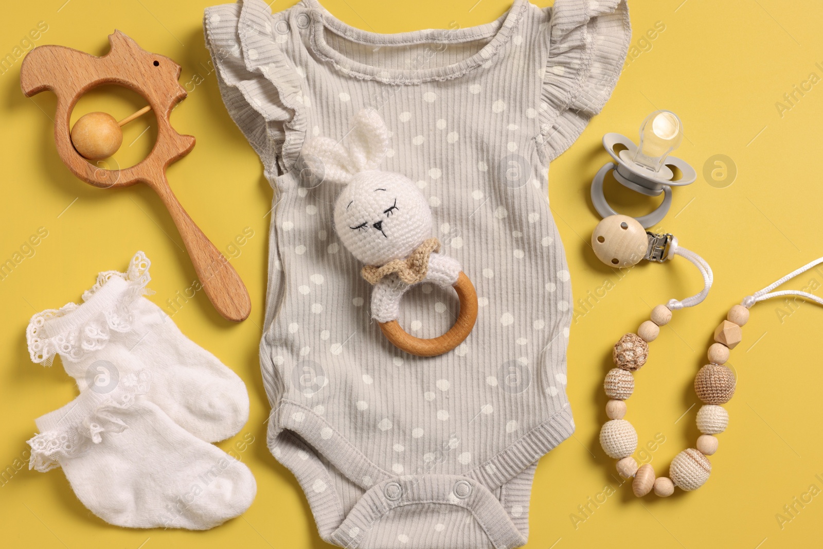 Photo of Different baby accessories on yellow background, flat lay