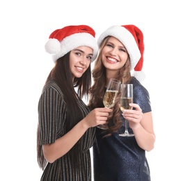 Photo of Beautiful young women in Santa hats with glasses of champagne on white background. Christmas celebration