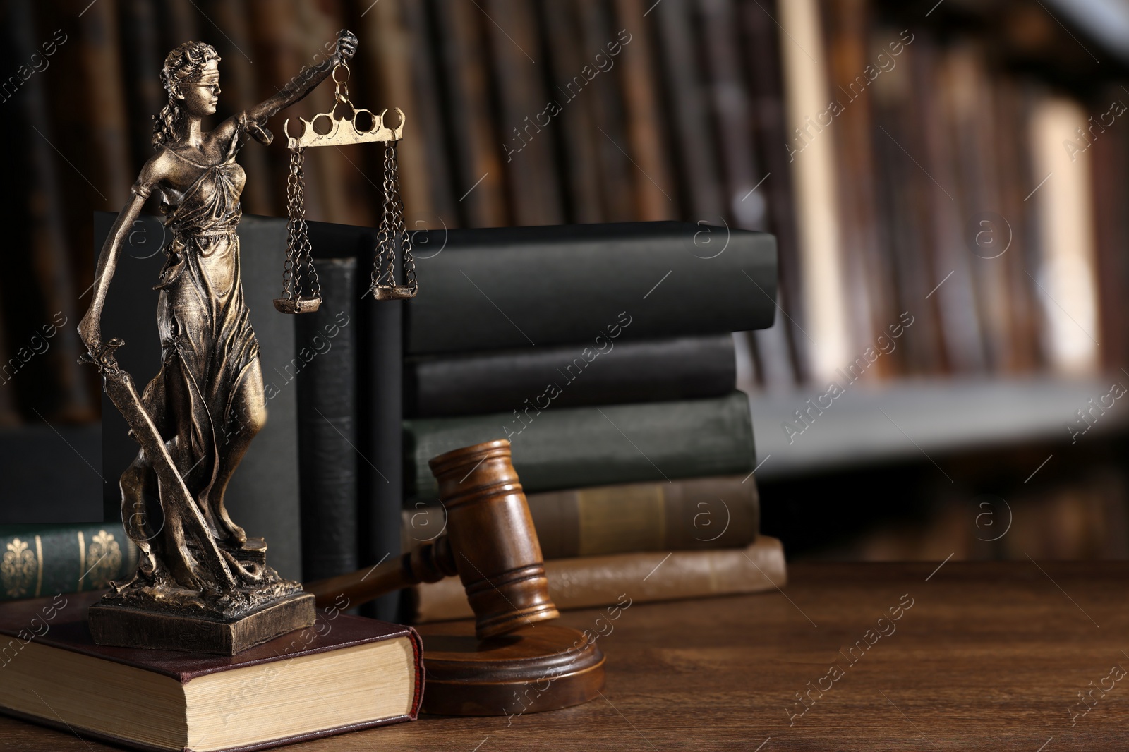 Image of Law. Statue of Lady Justice, gavel and books on wooden table indoors, space for text