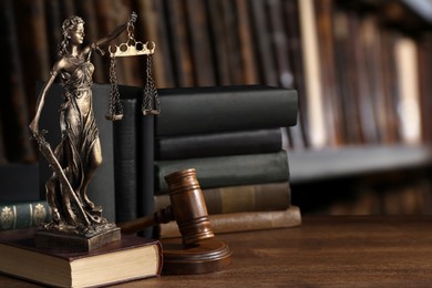 Law. Statue of Lady Justice, gavel and books on wooden table indoors, space for text