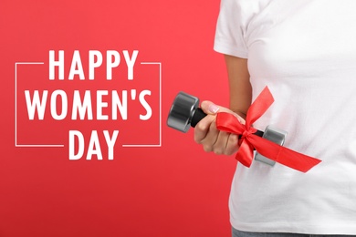 Image of Closeup view of woman with dumbbell as girl power symbol on red background. Happy Women's Day