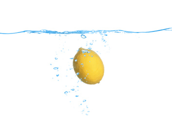 Ripe lemon falling down into clear water against white background