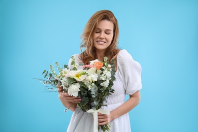 Photo of Beautiful woman with bouquet of flowers on light blue background