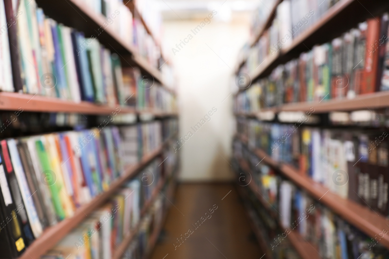 Photo of Blurred view of shelving units with books in library