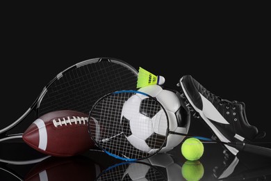 Photo of Many different sports equipment on black mirror surface