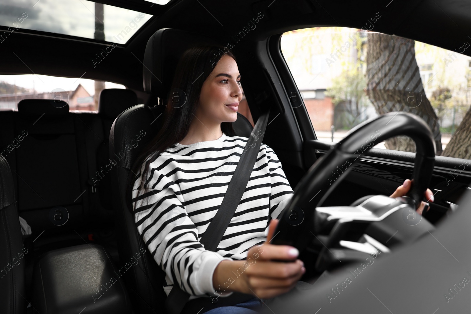 Photo of Woman with safety seat belt driving her modern car