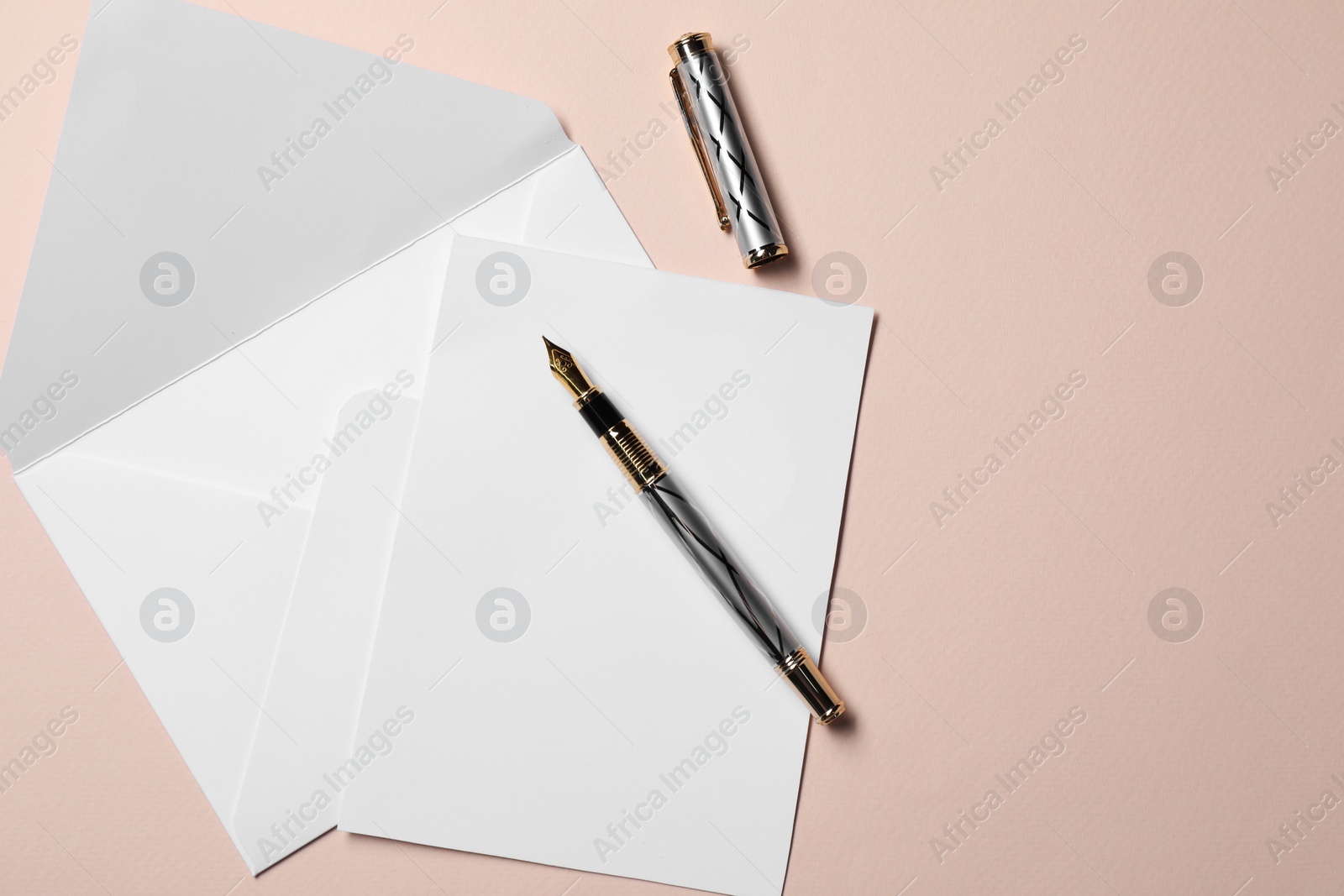 Photo of Blank sheet of paper, letter envelope and pen on beige background, top view. Space for text