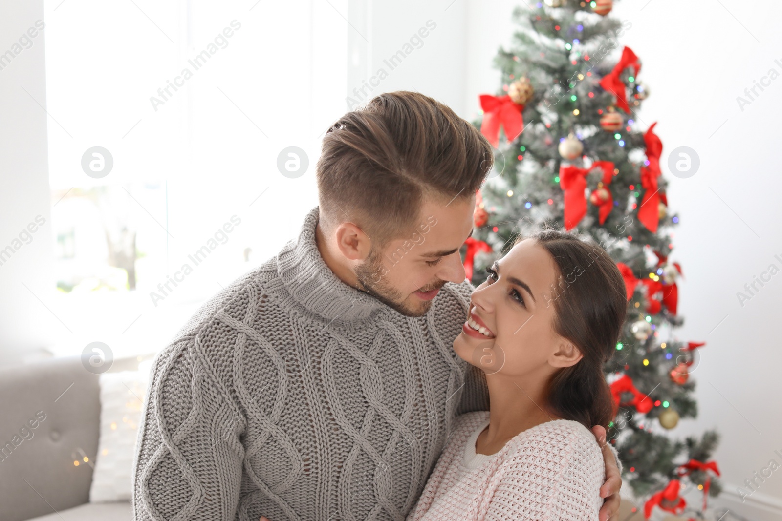 Photo of Happy young couple celebrating Christmas at home