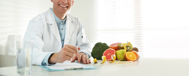 Image of Nutritionist at desk in his office, closeup. Banner design
