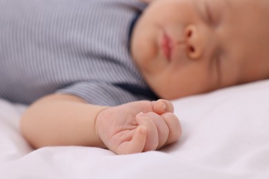 Photo of Cute newborn baby sleeping on white blanket, selective focus