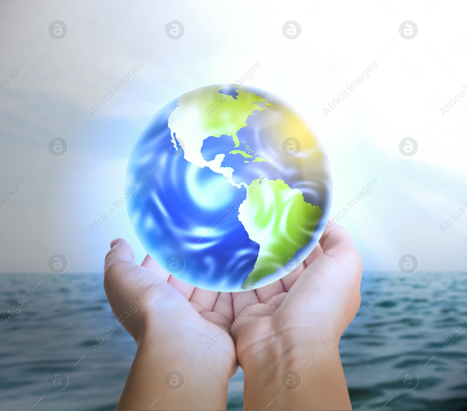 Image of Woman holding Earth near ocean, closeup view