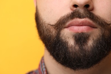 Photo of Handsome man with mustache on yellow background, closeup